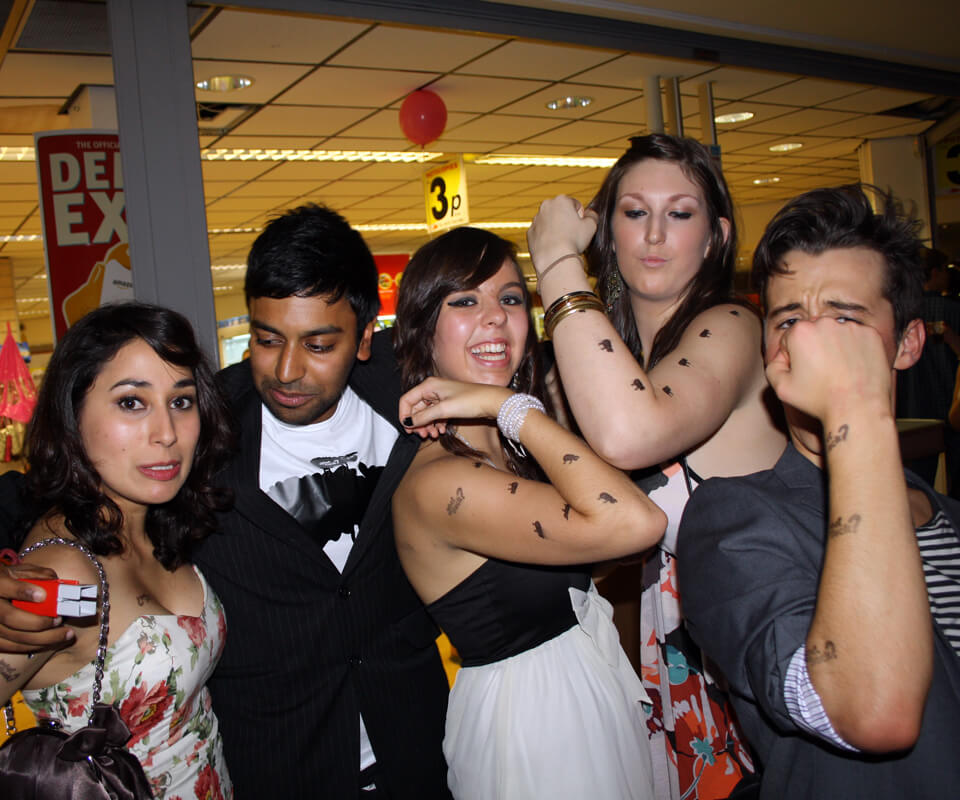 A group of students engaging with Magpie’s What the Flock youth substance misuse prevention campaign with black sheep stamps on their bodies.