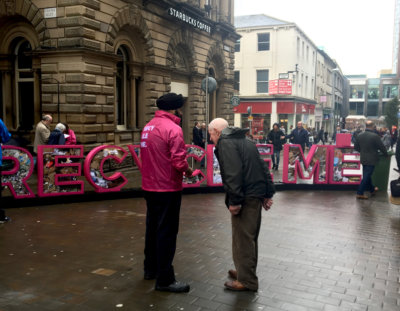 a photograph of a campaigner talking to a member of the public informing about the campaign