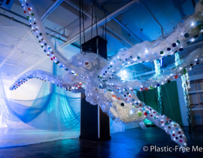 Giant octopus sculpture made from chicken wire, filled with white plastic and hanging from a ceiling