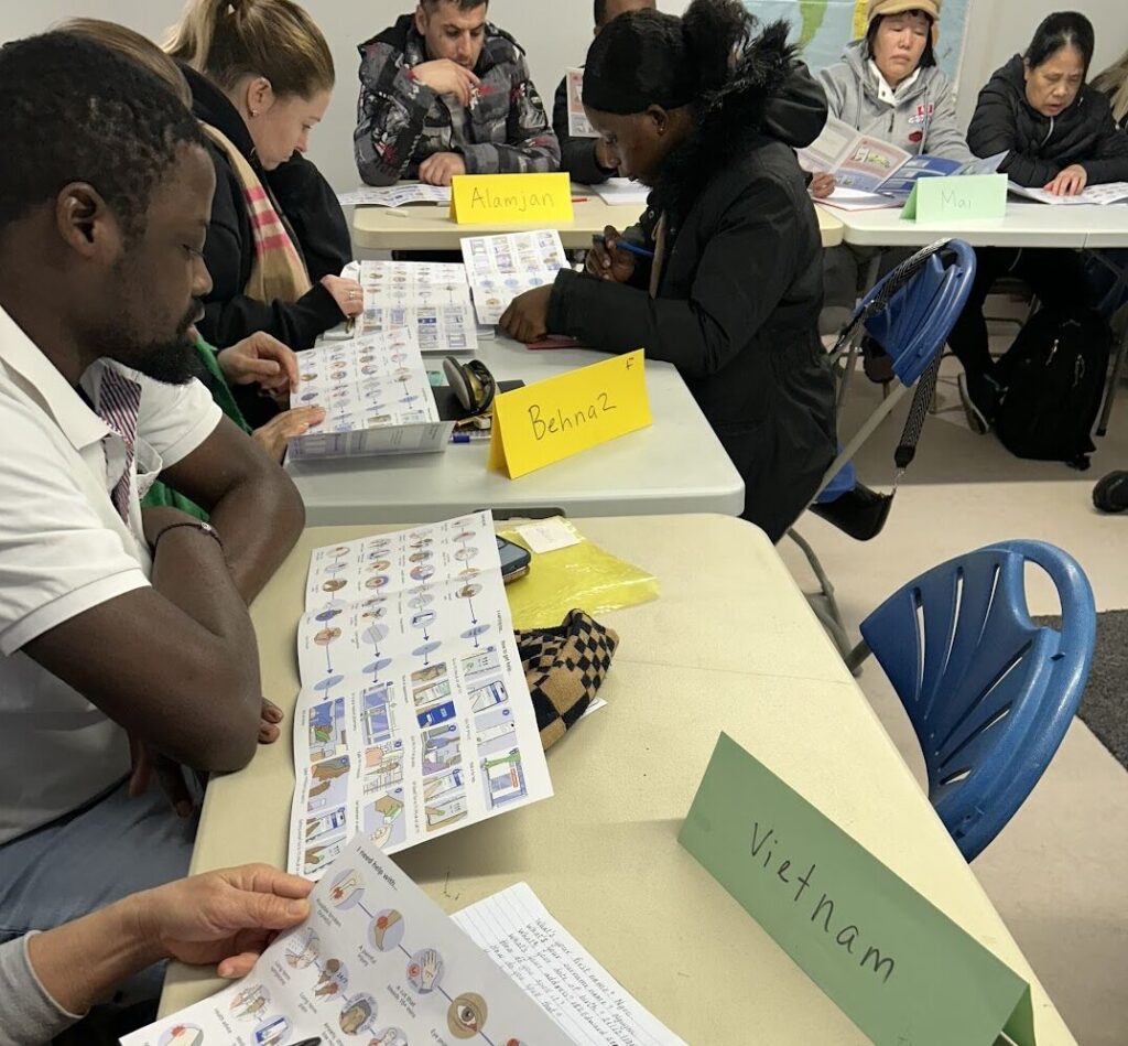 Participants in a co-creation workshop reviewing illustrated materials designed to improve NHS service navigation