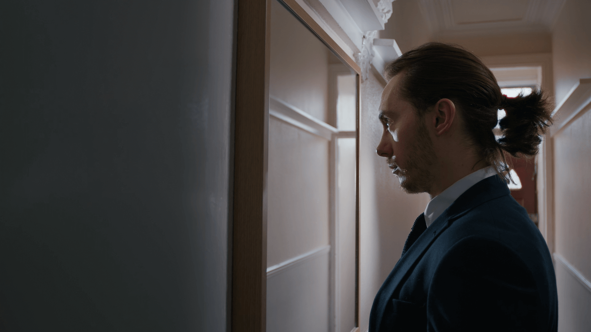 Man looking in the mirror dressed in a suit