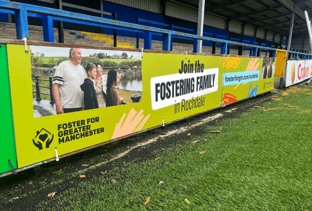 A Rochdale football pitch banner for the 'Join the Fostering Family' fostering recruitment campaign.