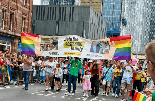 The 'Join the Fostering Family' team holding a banner at Manchester pride as part of the fostering recruitment campaign.