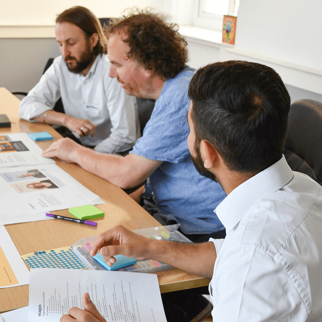 A group of men from bradford reviewing cancer screening creative