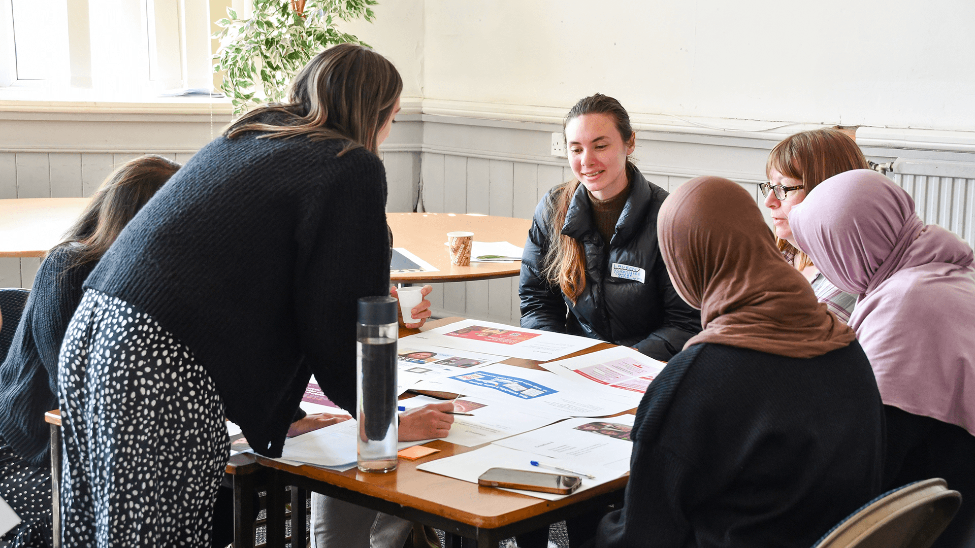 Community event showing a group of women from bradford reviewing creative designs.